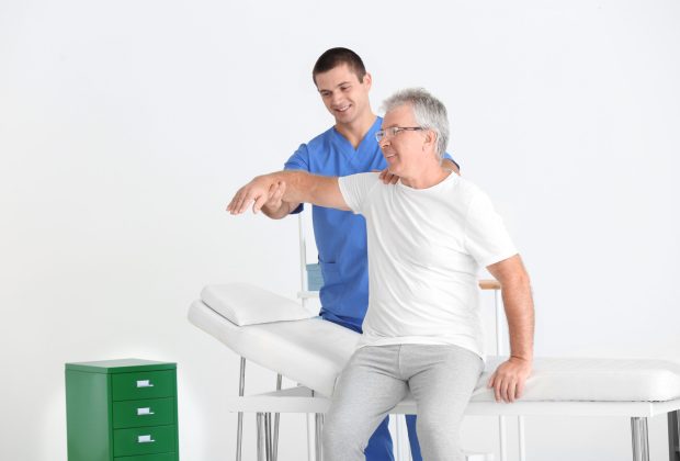 Physiotherapist working with senior patient in modern clinic Physiotherapist working with senior patient in modern clinic